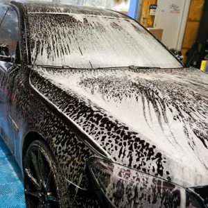 a black vehicle in the process of being exterior detailed
